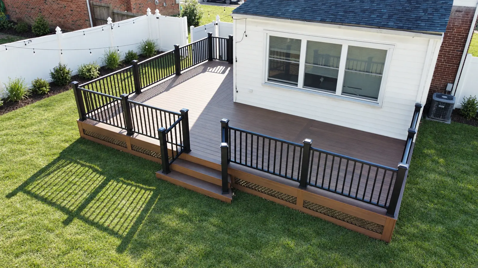 Zenna Decks deck with dark railings and steps leading to the backyard lawn